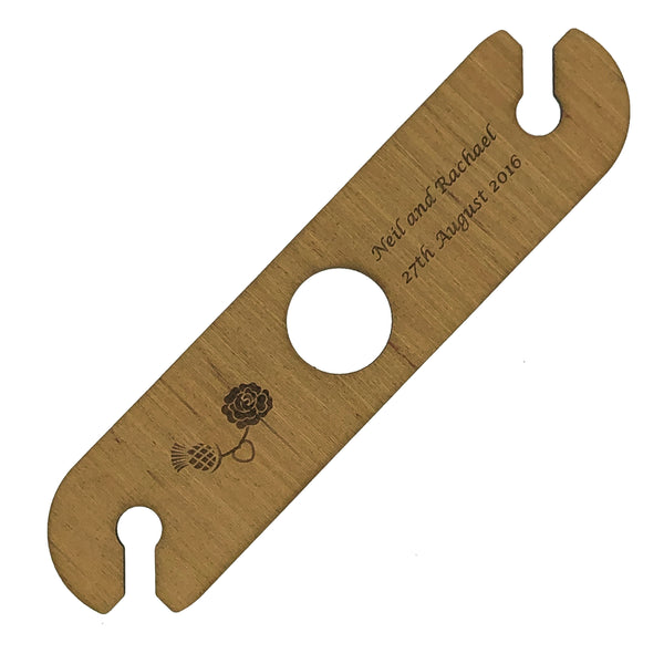 Personalised wine glass holder, meranti plywood, with hole for the nexk of the bottle and two holding places for glasses at each end - laser engraved with a thistle and rose motif and the names and dates for the wedding