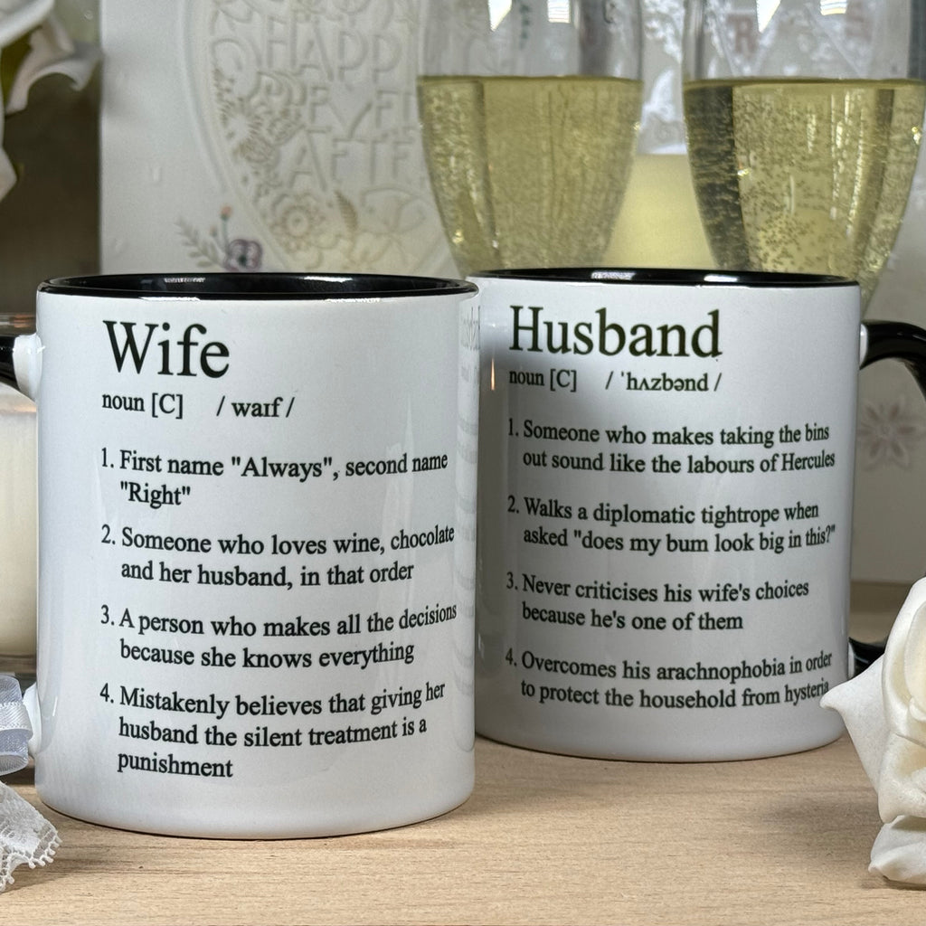 White ceramic mugs with humorouse definitions of a husband and wife printed in black