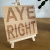 Wooden coaster gift - Scottish dialect - aye right - displayed on an easel