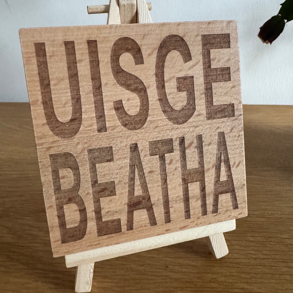 Wooden coaster gift - Scottish dialect - uisge beatha - displayed on an easel