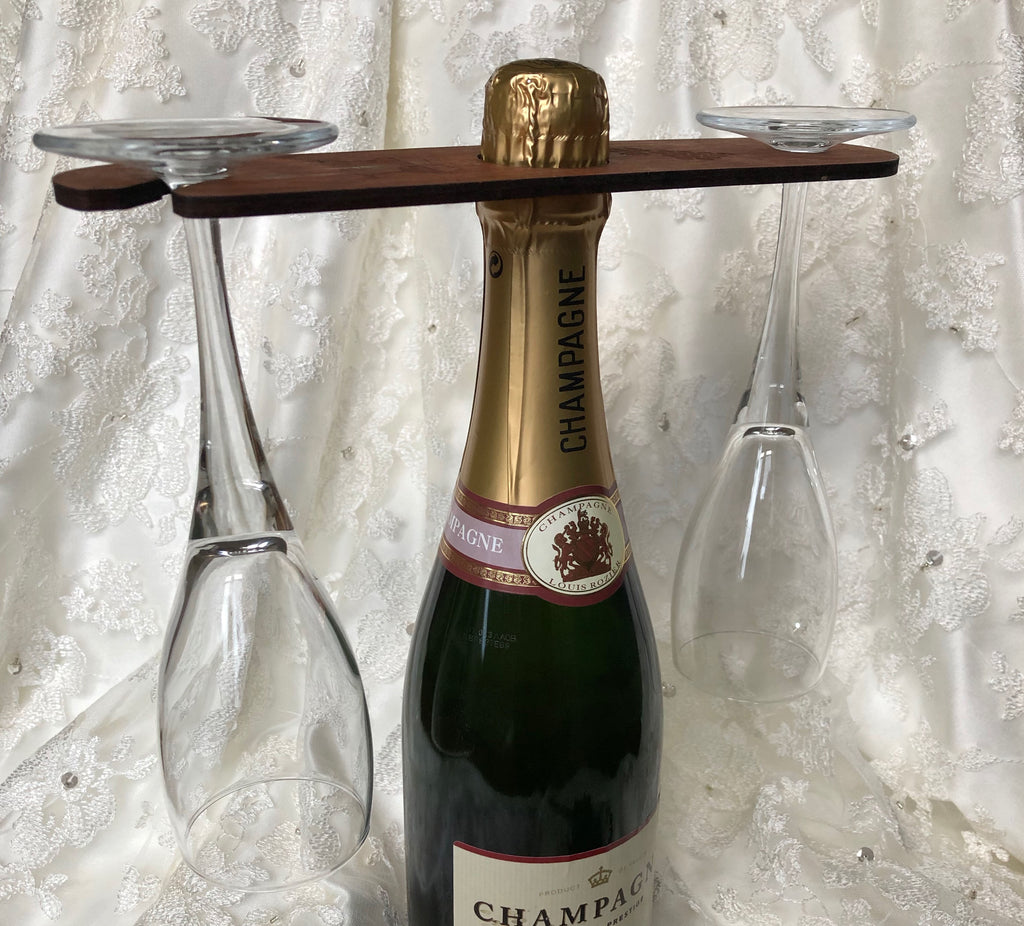 Personalised wine glass holder, meranti plywood, with hole for the nexk of the bottle and two holding places for glasses at each end - set against a wedding style backdrop